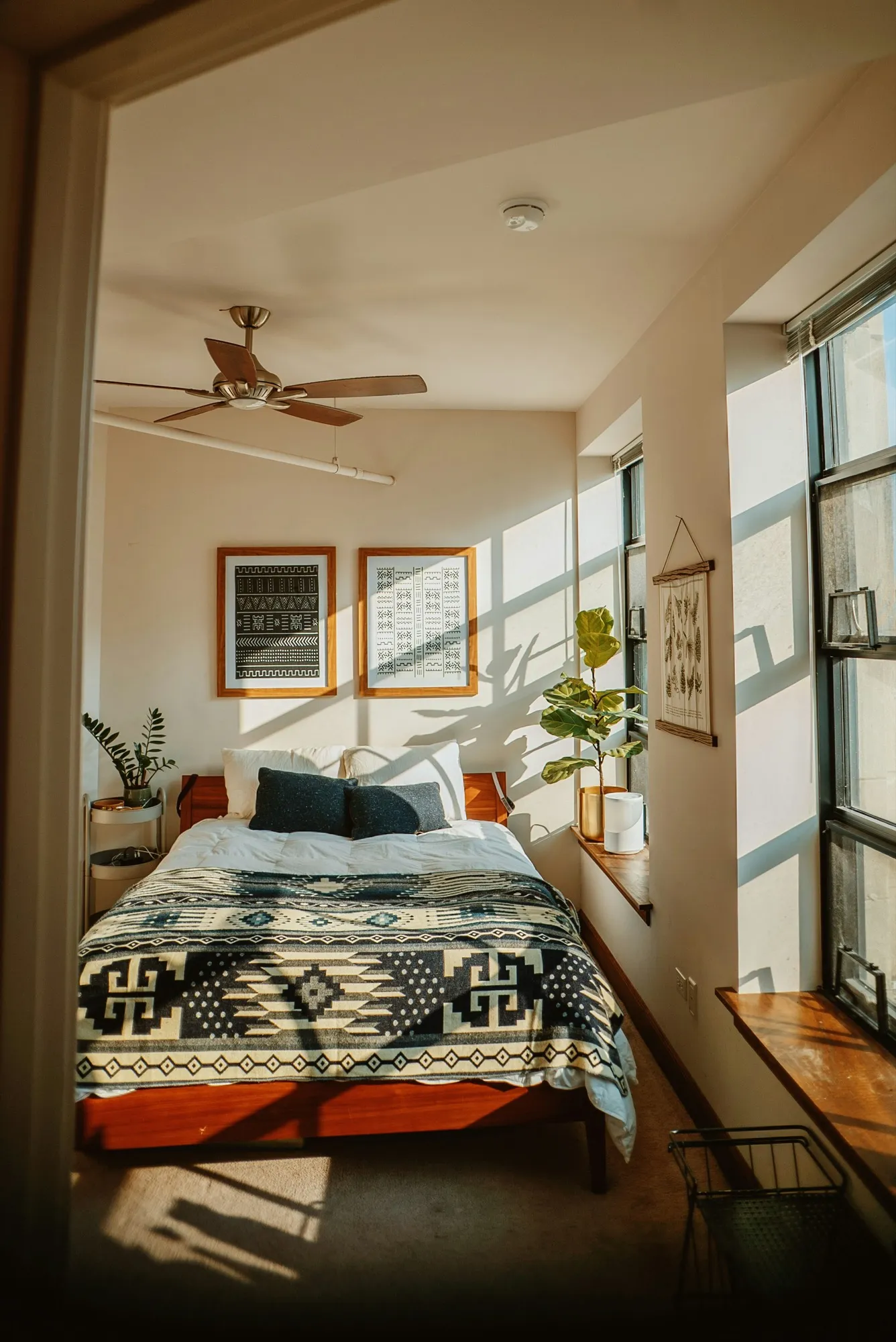 A sunlit bedroom with plants by the window
